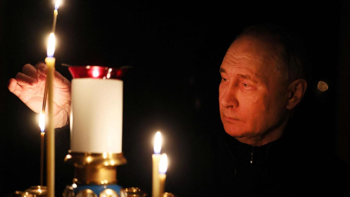 Vladimir Putin lights a candle during his visit to a church of the Novo-Ogaryovo state residence outside Moscow during a national day of mourning following the attack in the Crocus City Hall. — AFP
