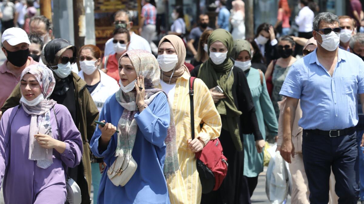 People wearing face masks walk downtown Ankara, Turkey, as Turkish authorities have made the wearing of masks mandatory in most of the country to curb the spread of Covid-19. Photo: AFP