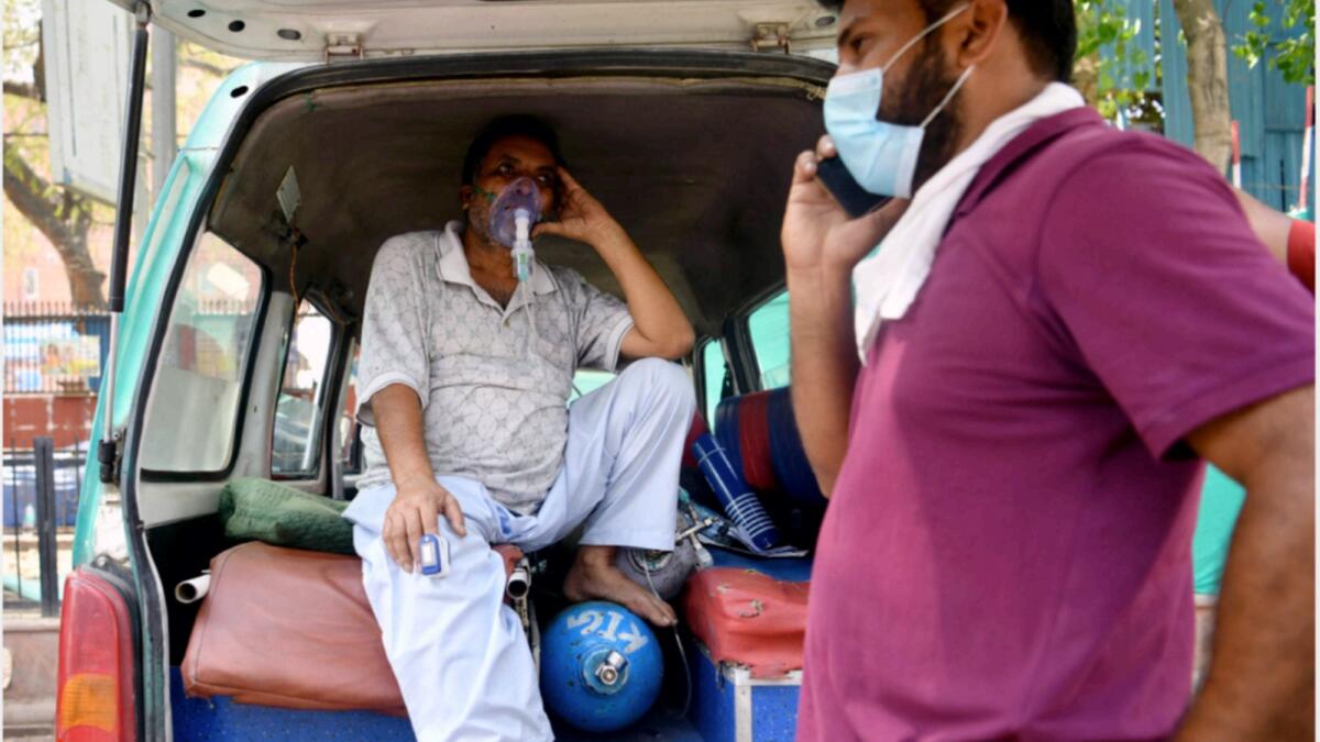 A Covid-19 patient on oxygen support waits in an ambulance outside LNJP Hospital in New Delhi. — New Delhi