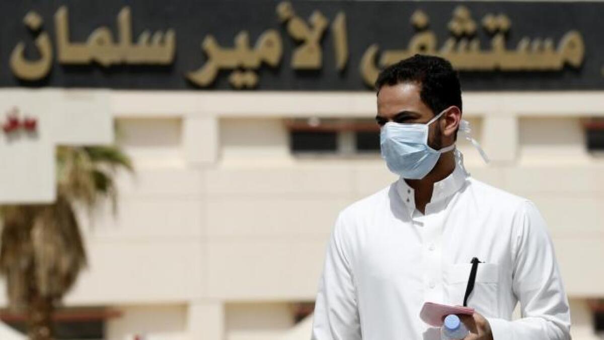 A man wearing a mask walks outside a hospital, in Riyadh in this file photograph.