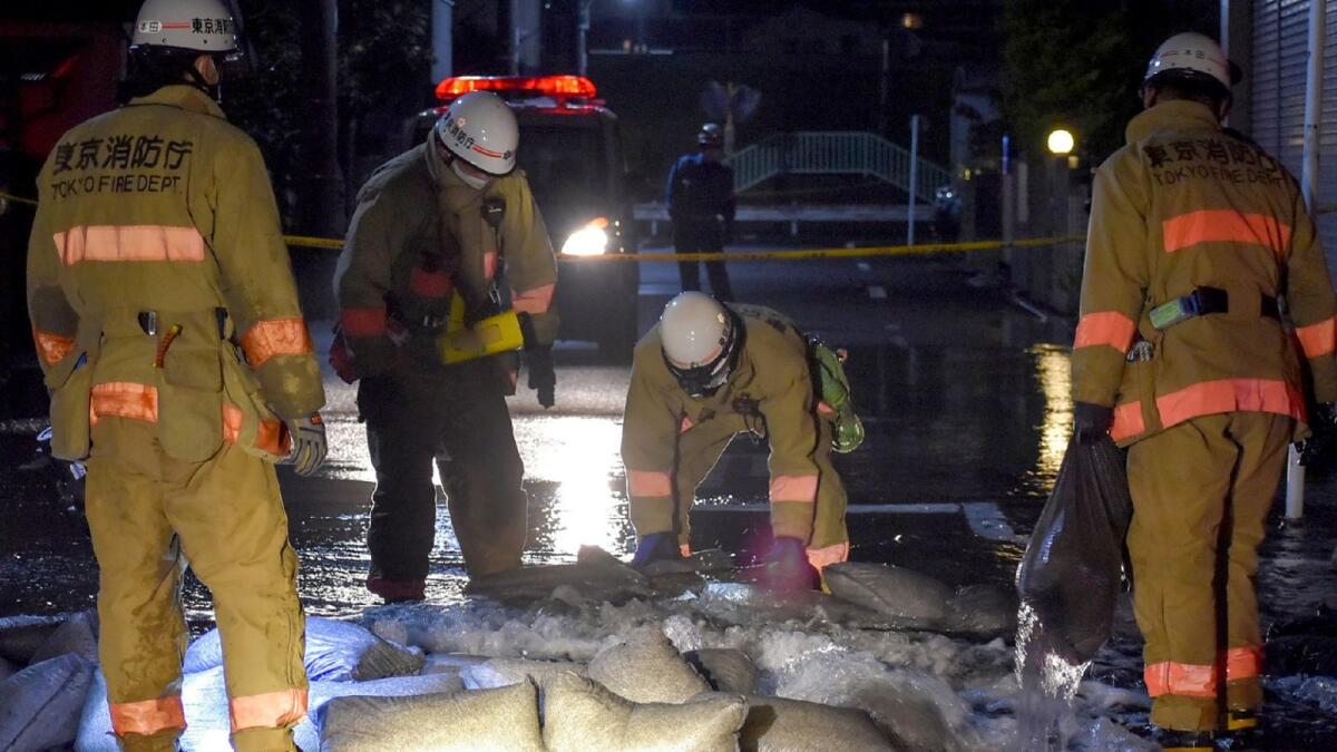 Tokyo Fire Department team tries to fix a broken water pipe in Tokyo after a 6.1-magnitude earthquake shook the Japanese capital and surrounding areas.