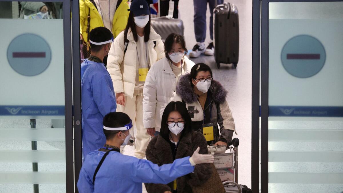 A South Korean soldier wearing personal protective equipment (PPE) guides a group of Chinese tourists for coronavirus disease (COVID-19) tests upon their arrival at the Incheon International Airport in Incheon, South Korea, January 4, 2023. Photo: Reuters