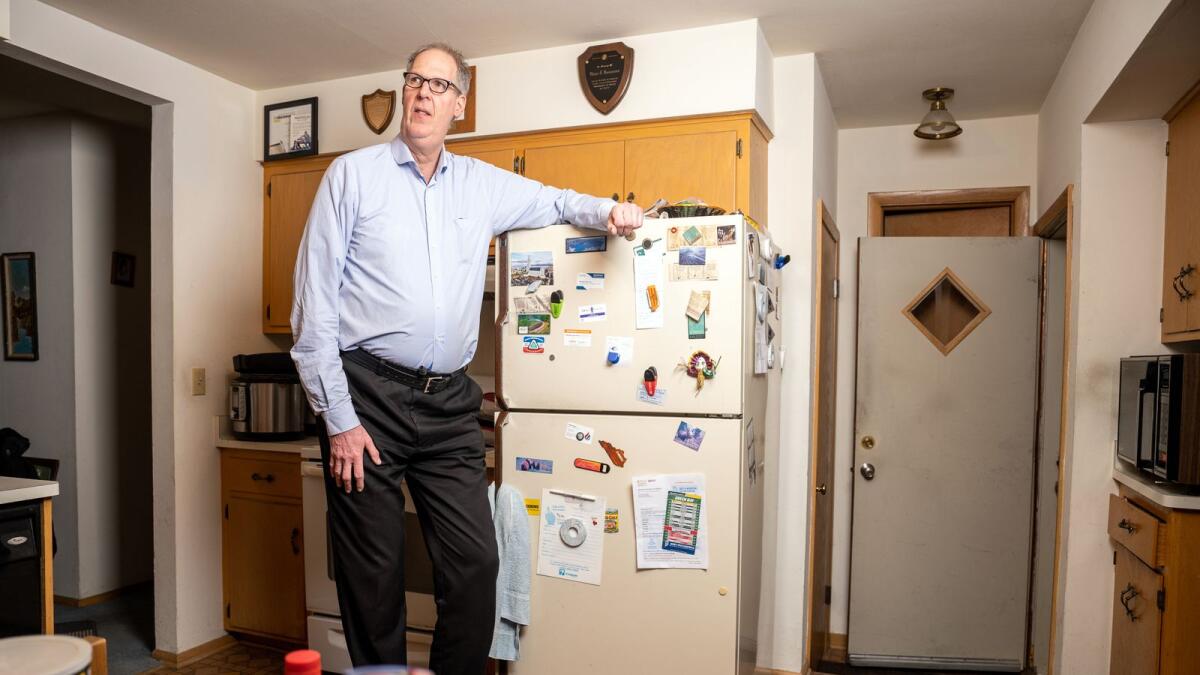 Dave Rasmussen at his home in Glendale, Wisconsin, on March 9, 2023. Rasmussen is 7 feet, 2 inches tall and has got used to people asking (and asking) if he played basketball. (Sara Stathas/The New York Times)