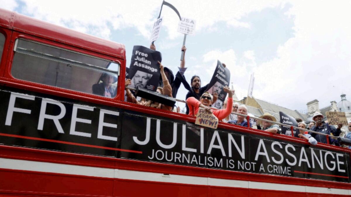Protesters ride on a bus during a 'Free Assange' demonstration to mark WikiLeaks founder's birthday. — Reuters