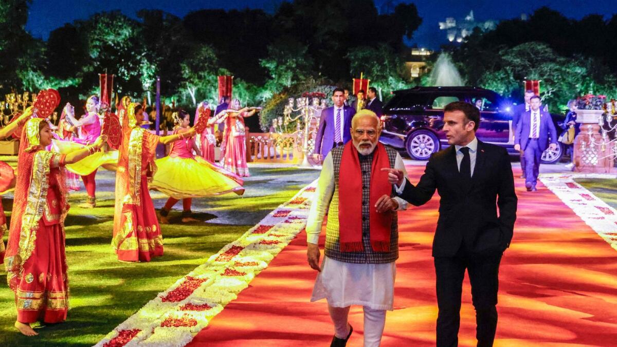 Narendra Modi and Emmanuel Macron arrive at Rambagh Palace following a roadshow in Jaipur. — AFP