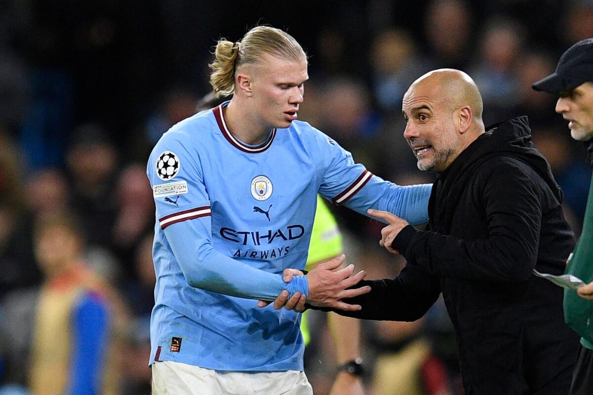Manchester City manager Pep Guardiola (right) speaks with striker Erling Haaland (left) during the Champions League match against Bayern Munich. — AFP