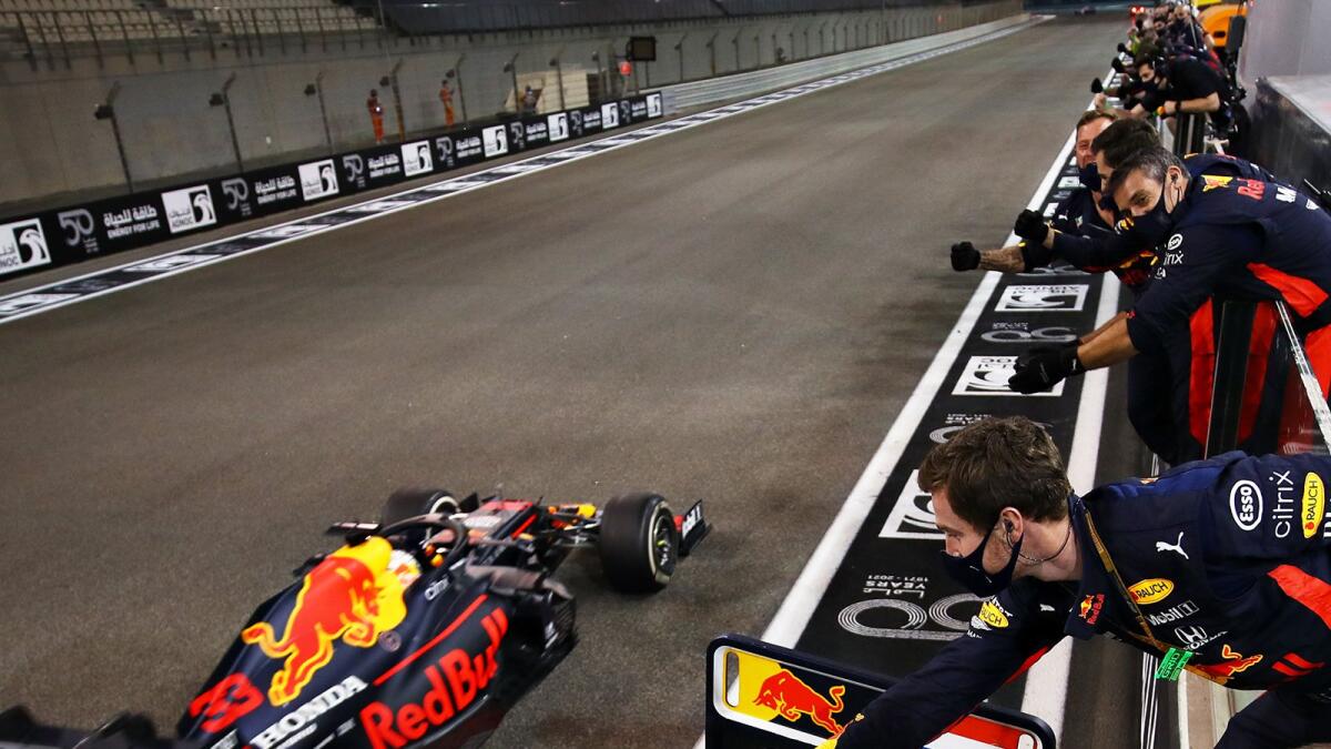 Red Bull Racing's Max Verstappen takes the chequered flag at the Yas Marina Circuit to win the Formula One Etihad Airways Abu Dhabi Grand Prix on Sunday. — Aston Martin Red Bull Racing Twitter