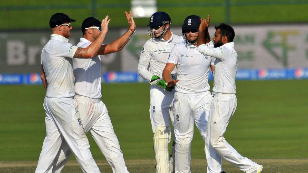 England players celebrate a Pakistani wicket in the first Test in Abu Dhabi. England were denied a dramatic win after umpires called off play eight overs earlier due to bad light. — Photo by Nezar Balout