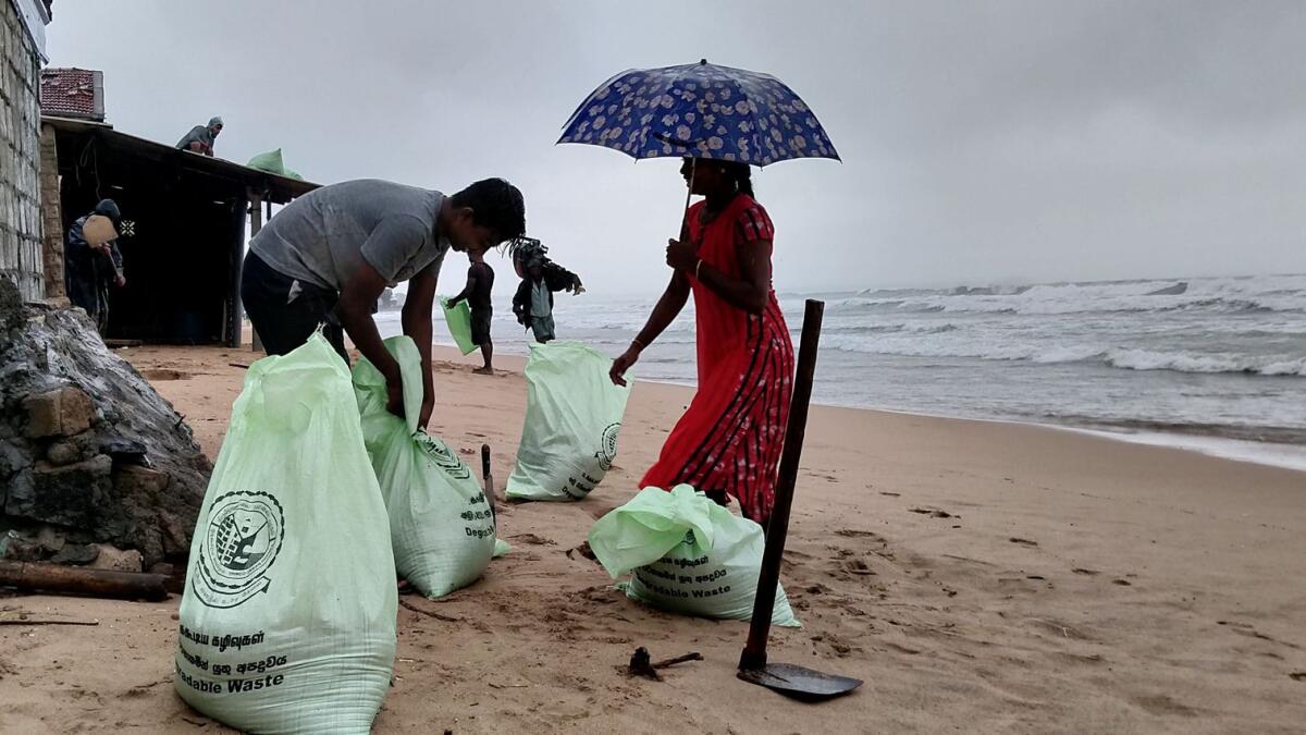People fills plastic sacks with sand to cover their houses as Cyclone Burevi is expected to near the coast of Trincomalee, Sri Lanka.