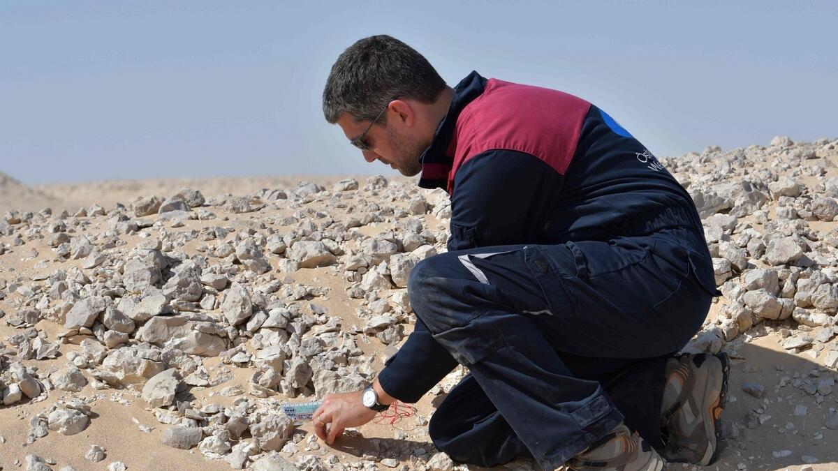 A member of the Austrian Space Forum inspects a site in Omans Dhofar desert, near the southern Marmul outpost.- AFP