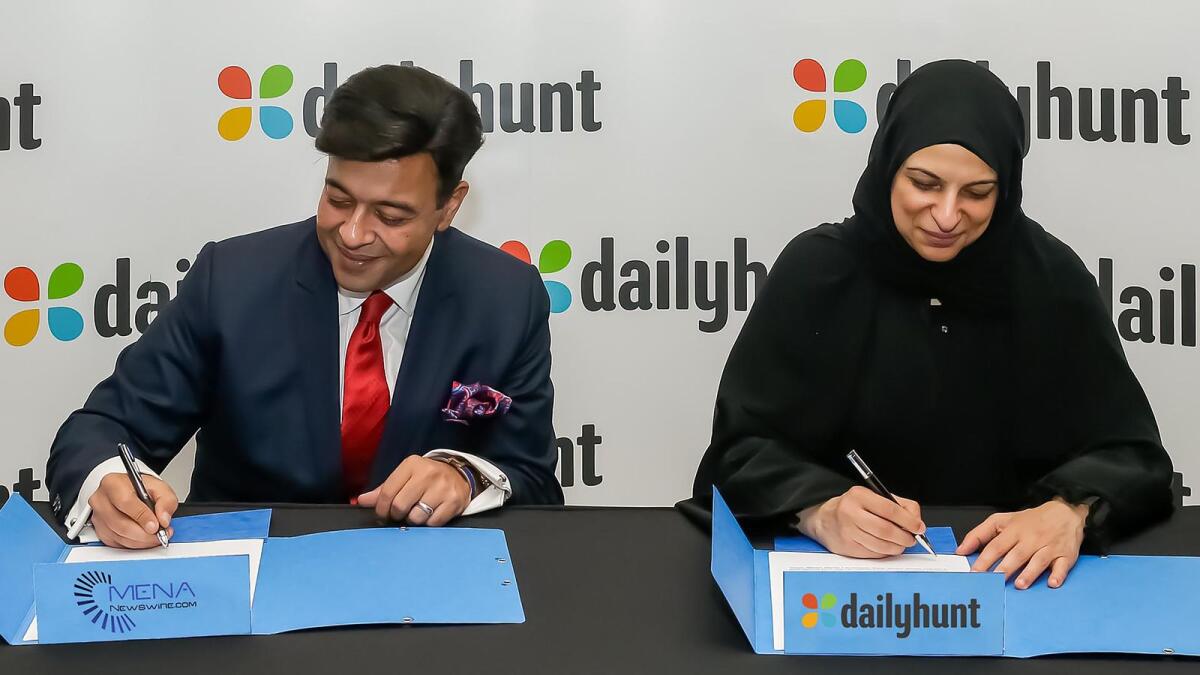Umang Bedi, co-founder, VerSe Innovation, and  Heba Al Mansoori, co-founder and chairperson of Mena Newswire, signing the agreement. — Supplied photo