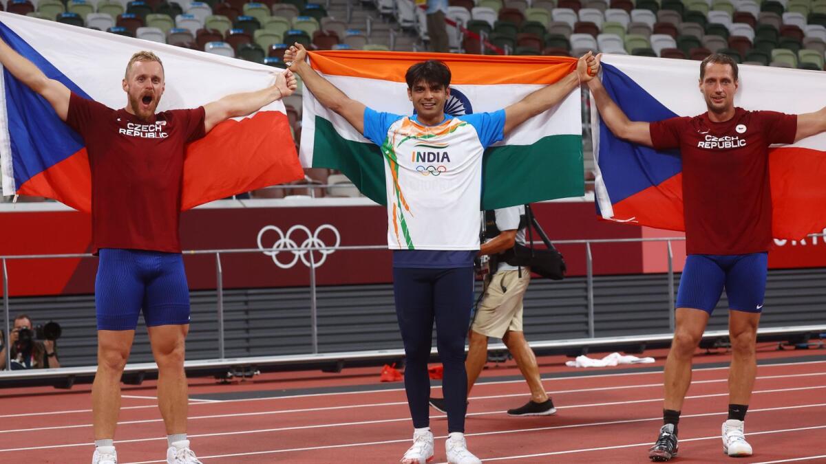 Neeraj Chopra of India celebrates with his national flag after winning gold alongside silver medallist Jakub Vadlejch of Czech Republic and bronze medallist Vitezslav Vesely of Czech Republic.— Reuters