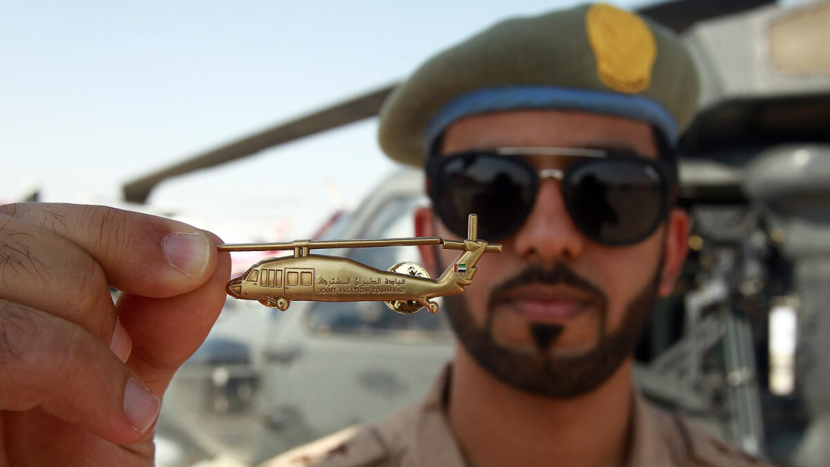 A UAE Soldier shows the miniature of a Black Hawk during the Dubai Air Show.- Photo by Shihab/Khaleej Times