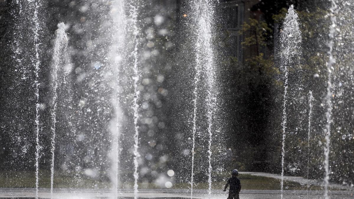 A child cools off under a public fountain as a heatwave rolls over Nice, France.  Photo: Reuters