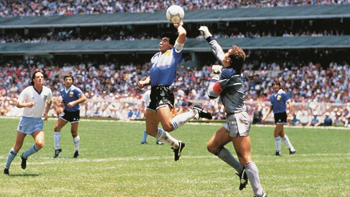 A file photo shows Argentina's Diego Maradona using his left hand to score a goal against England during the 1986 World Cup. — Twitter
