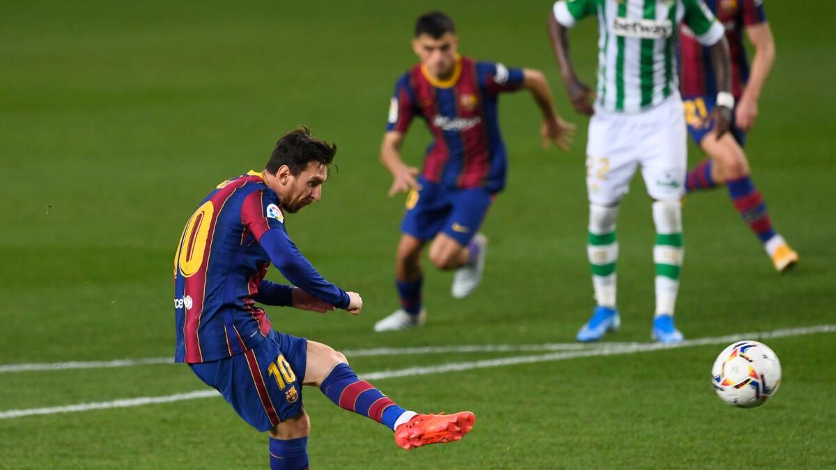 Lionel Messi shoots a penalty kick and scores a goal during the Spanish League match against Real Betis. — AFP