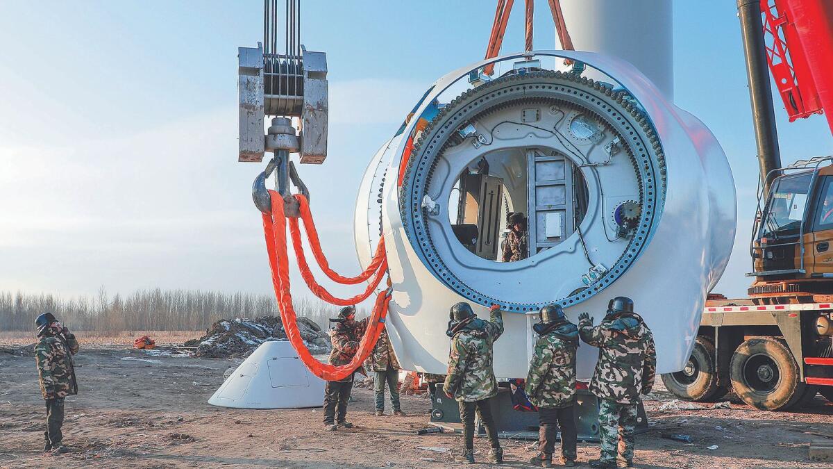 Technicians install turbines at a wind farm in Hinggan League, Inner Mongolia autonomous region, in December. Wang Zheng / For China Daily
