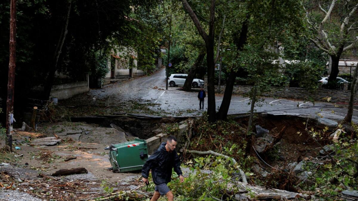 A man walks past a collapsed road after torrential rains destroyed the infrastructure and caused flooding in the area in the village of Ano Meria, near Volos,central Greece, September 6, 2023.  Photo: Reuters