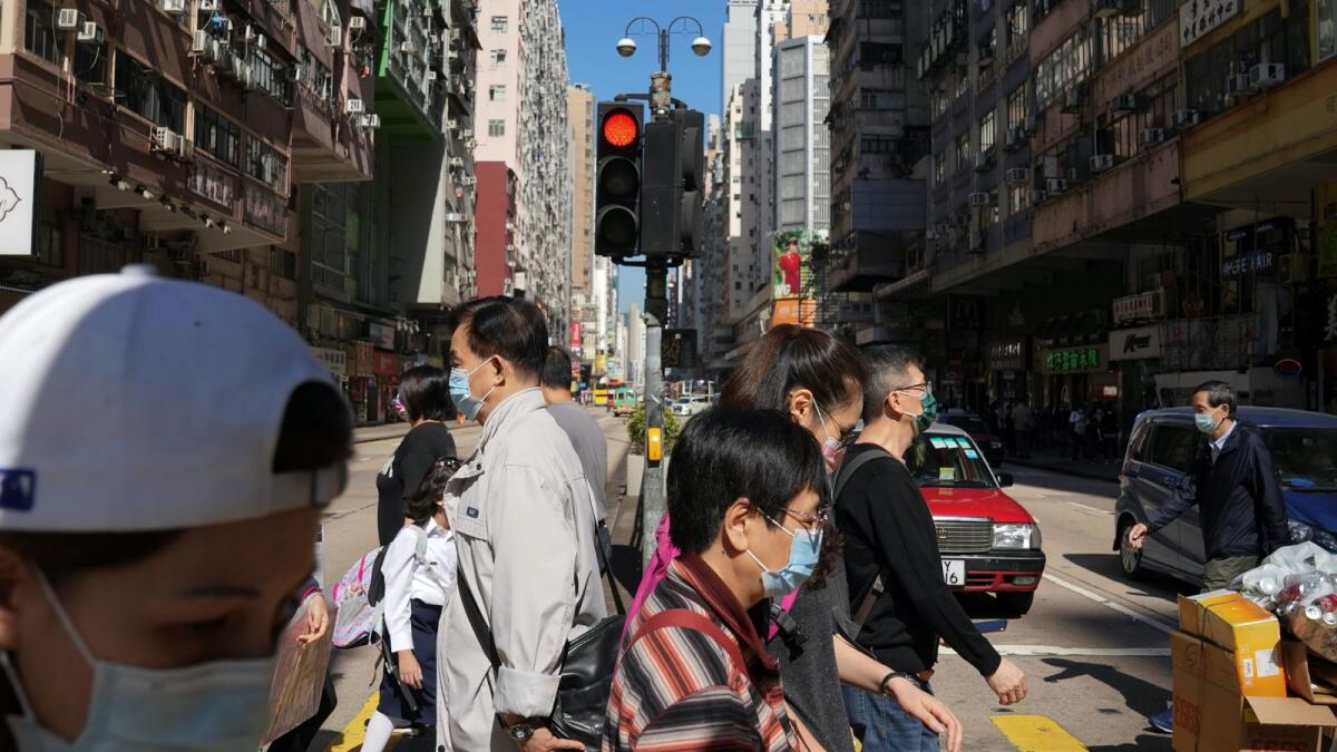 People wearing face masks to prevent the spread of the coronavirus disease (COVID-19), walk on a street in Hong Kong, China November 29, 2021. REUTERS/Lam Yik