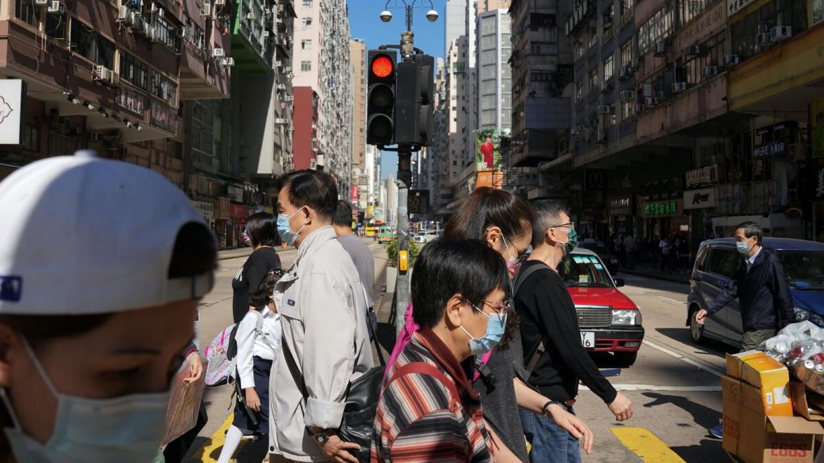 People wearing face masks to prevent the spread of the coronavirus disease (COVID-19), walk on a street in Hong Kong, China November 29, 2021. REUTERS/Lam Yik