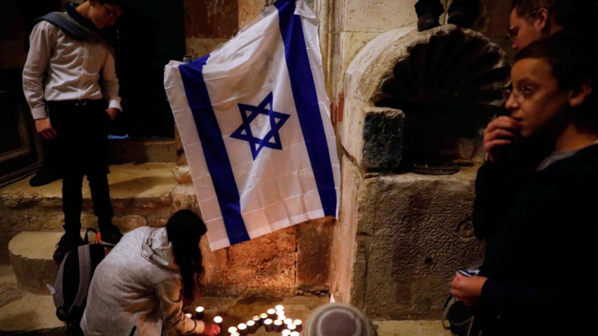 Israeli youth light candles at the site of a shooting attack that killed an Israeli man in Jerusalem's Old City. — AP