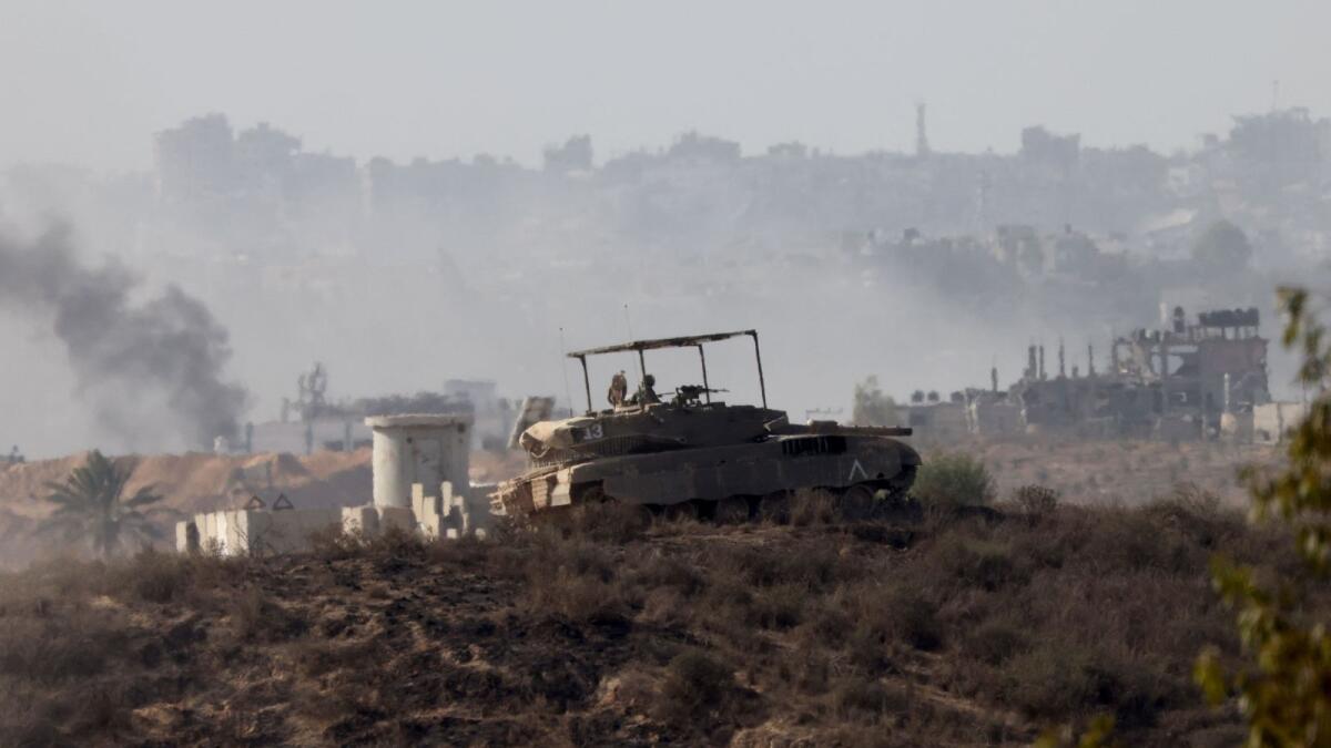 This picture taken from the Israeli side of the border with the Gaza Strip on Friday, shows an Israeli army tank in the northern part of the Palestinian enclave. — AFP