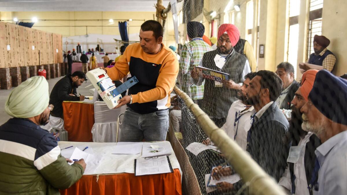 Electoral officials and polling agents work at a counting center during the counting of the Punjab state assembly election votes in Amritsar on March 10, 2022. Photo: AFP