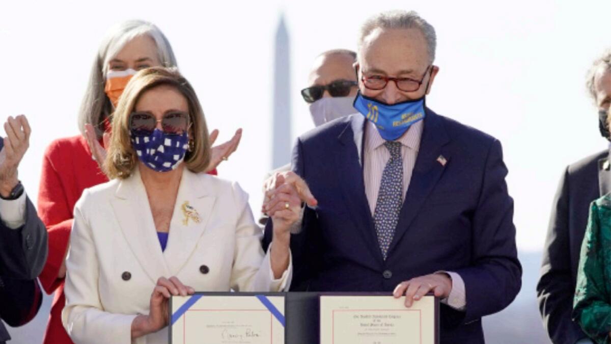 US House Speaker Nancy Pelosi and Senate Majority Leader Chuck Schumer pose after signing the $1.9 trillion Covid-19 relief bill during an enrollment ceremony on Capitol Hill on Wednesday. — AP