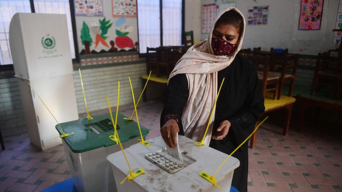 A woman cast her ballot to vote at a polling station during Pakistan's national elections in Karachi on Thursday. Photo: AFP