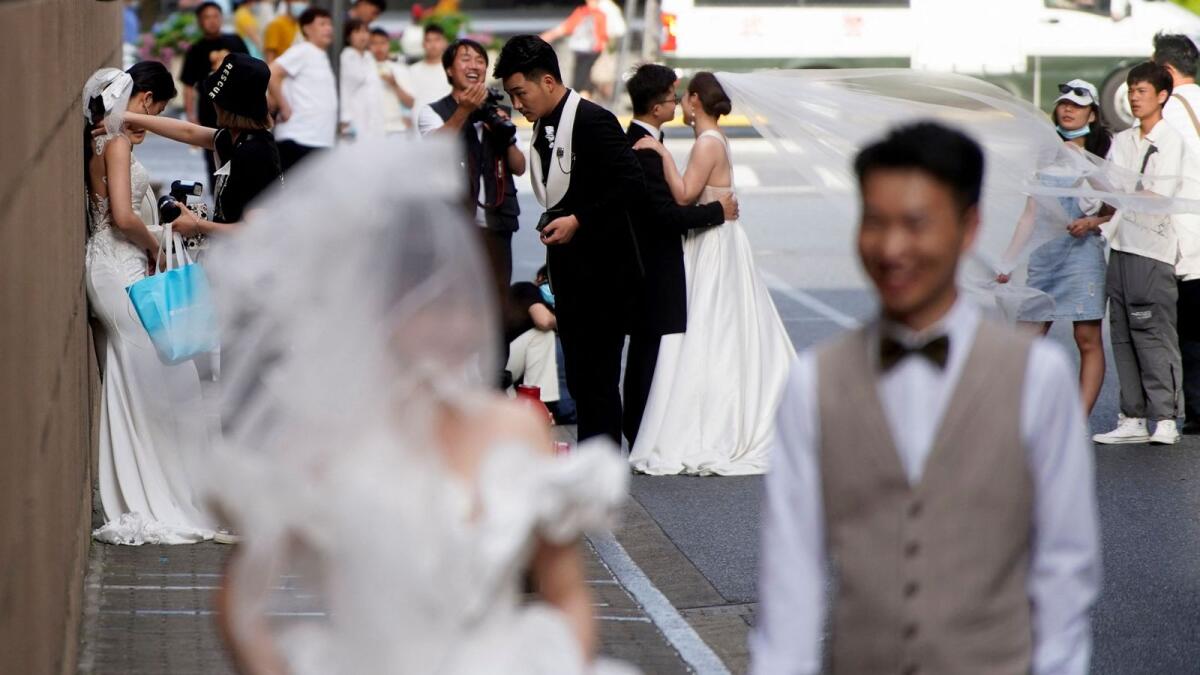 Couples prepare to have their photo taken during a wedding photo shoot on a street in Shanghai, China,  on May 31, 2021. — Reuters file