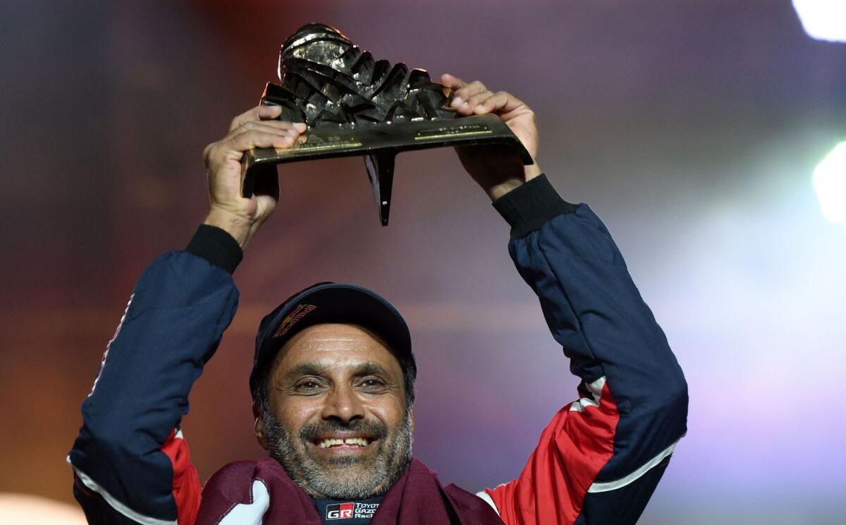 Toyota's Qatari driver Nasser Al-Attiyah holds his trophy on the podium after winning the 2023 Dakar Rally. — AFP
