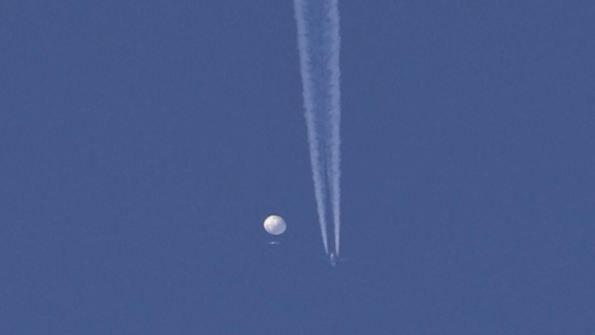 A large balloon drifts above the Kingstown, NC area, with a plane and its contrail seen below it. The United States says it is a Chinese spy balloon moving east over America at an altitude of about 60,000 feet but China insists the balloon is just an errant civilian airship used mainly for meteorological research that went off course. — AP