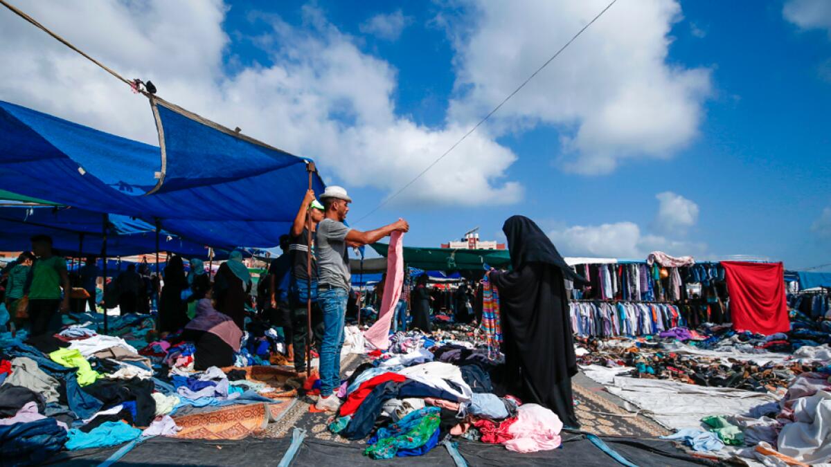A Palestinian woman shops at a stall in an outdoor market which has reopened after the Covid-19 lockdown in the Nuseirat refugee camp in central Gaza Strip. Photo: AFP&lt;br&gt;&lt;/br&gt;Research: Mohammad Thanweeruddin/Khaleej Times