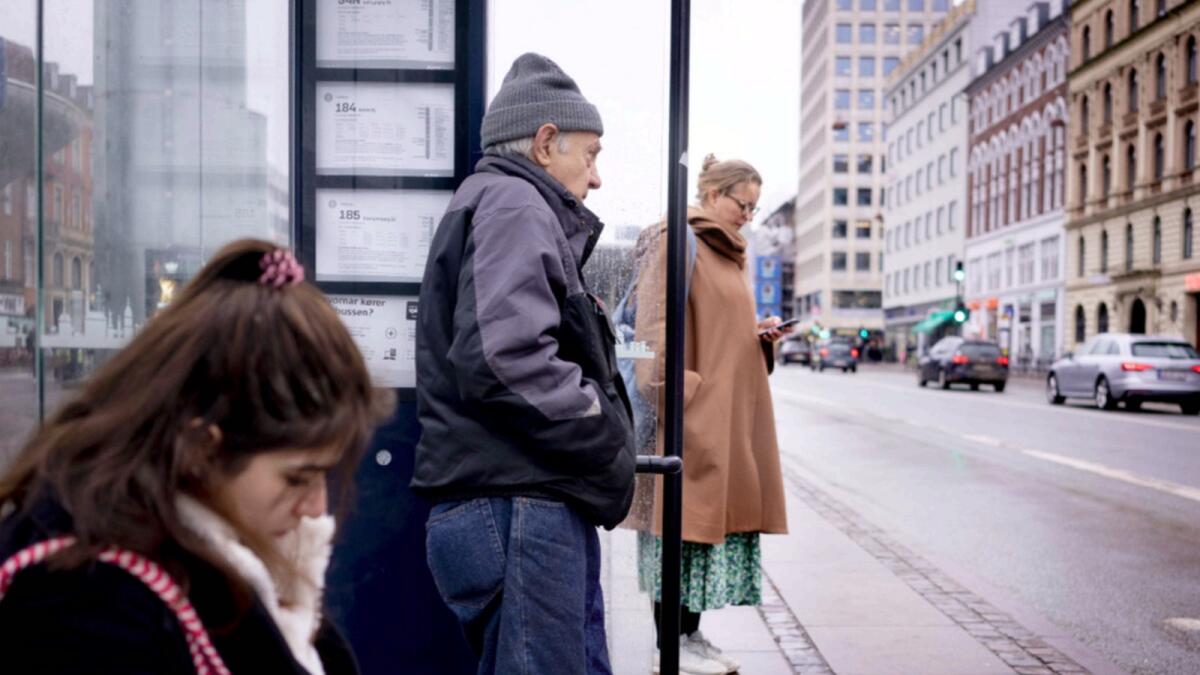 Passengers at a bus stop in Copenhagen, Denmark. — AP
