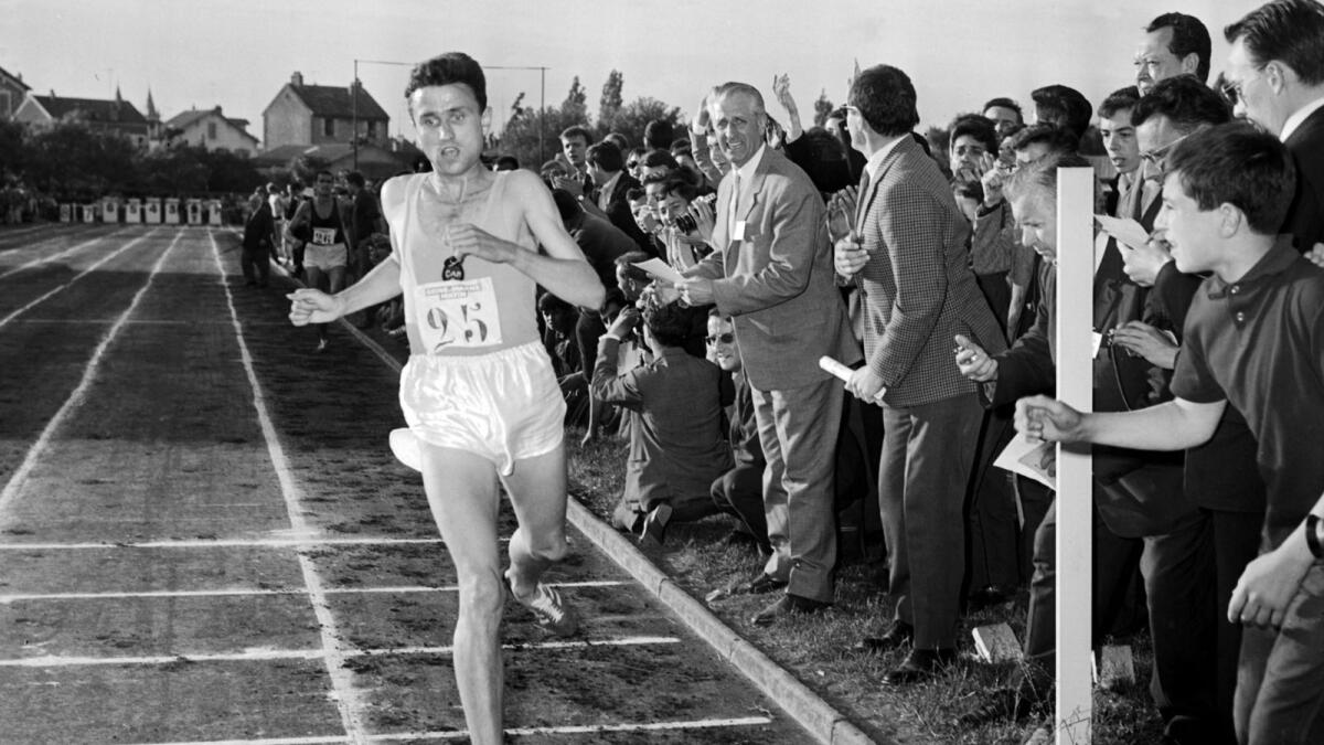 France's Michel Jazy, cheered on by the crowd, crosses the finish line at a meeting in Melun on June 24, 1965, where he set two new world records. Photo: AFP file