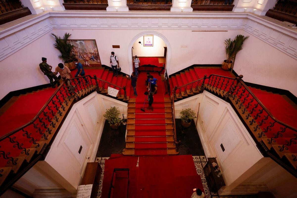 A man sweeps the stairs inside the President's house after President Gotabaya Rajapaksa fled, amid the country's economic crisis, in Colombo, Sri Lanka July 14, 2022/ Reuters