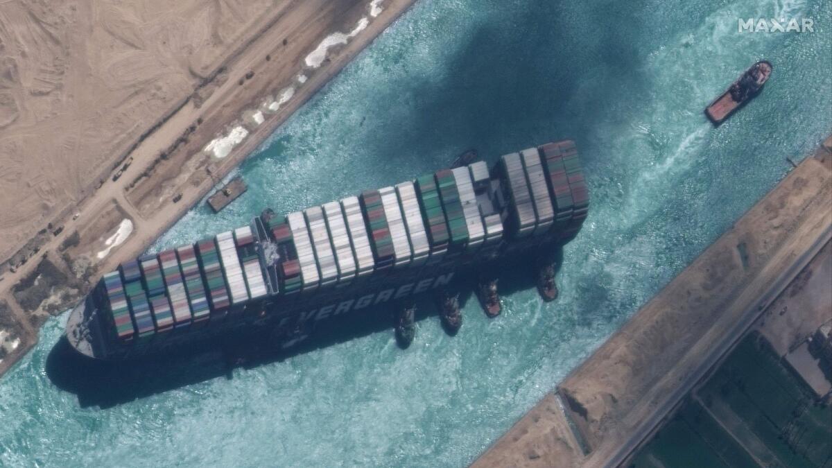 The satellite image shows a close up overview of the MV Ever Given container ship and tugboats in the Suez Canal on March 29.