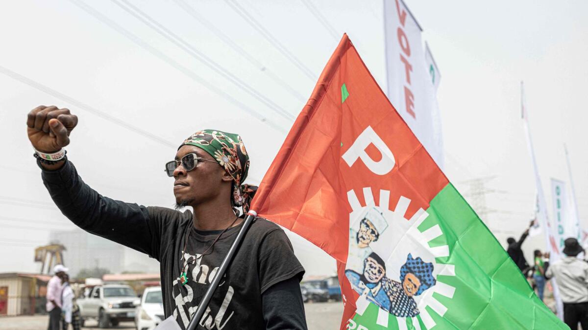 A supporter of candidate of Labour Party Peter Obi holds a party flag in Lagos on Saturday ahead of the Nigerian presidential election. — AFP