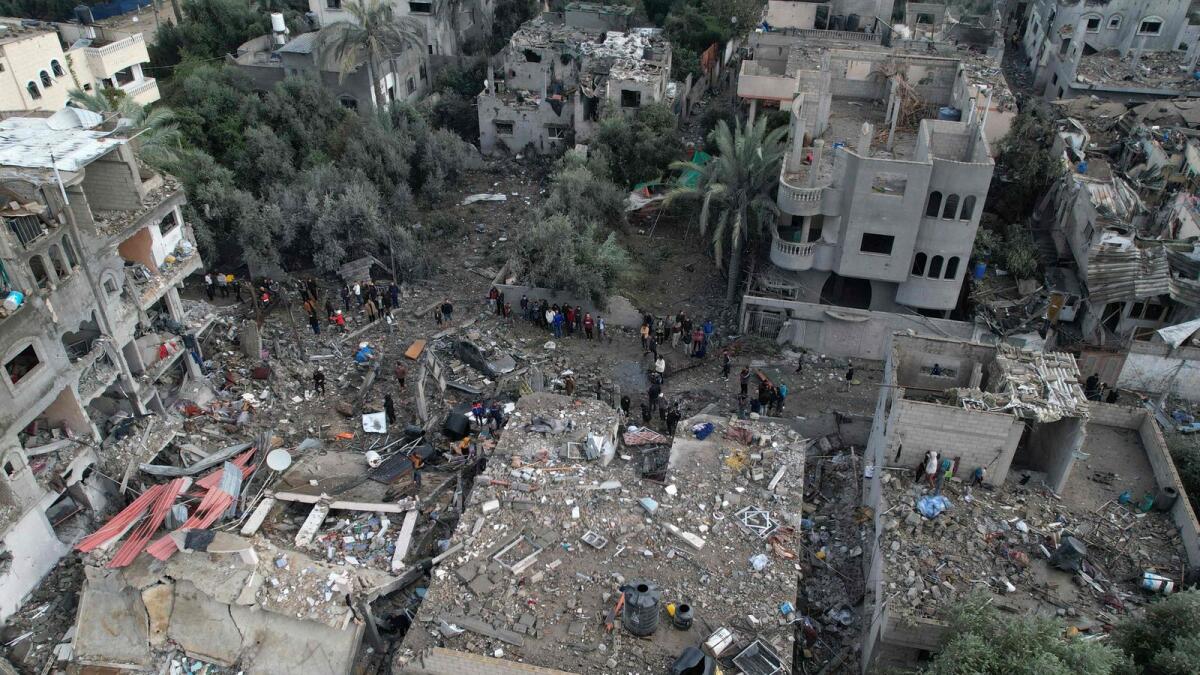 An aerial view shows Palestinians inspecting the damage at the Al Maghazi refugee camp after an overnight Israeli strike. — AFP
