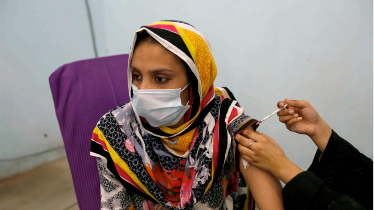 A woman receives Covid-19 vaccine from a paramedic at a vaccination center, in Lahore. — AP