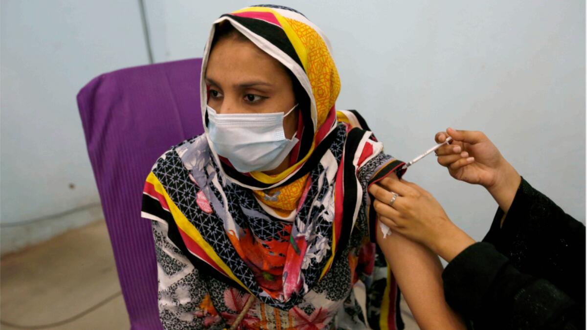 A woman receives Covid-19 vaccine from a paramedic at a vaccination center, in Lahore. — AP