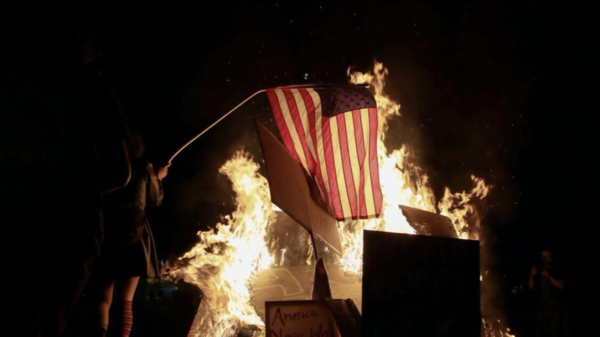A demonstrator sets fire to an American flag during a protest against racial inequality and police violence in Portland, Oregon, US. Photo: Reuters