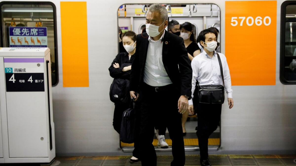 Passengers wearing protective masks get off a subway train at Shibuya station amid the coronavirus disease outbreak in Tokyo, Japan, on May 27, 2020.