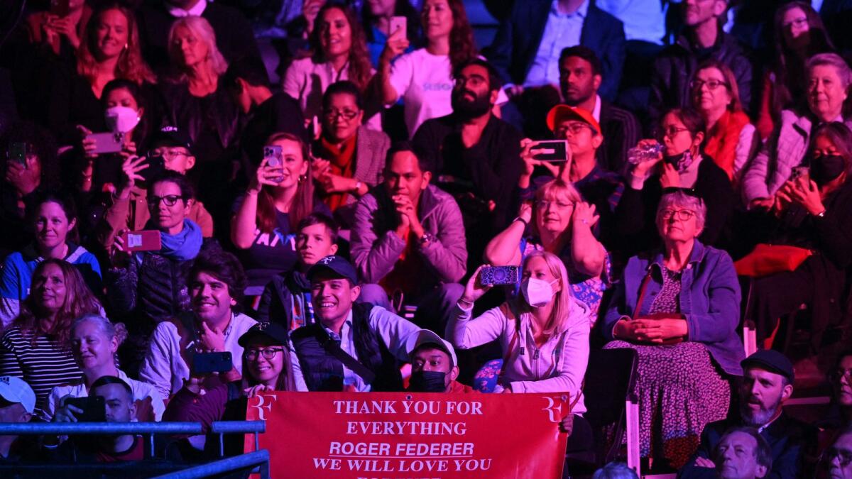 Fans hold a sign thanking Roger Federer during a practice session. — AFP