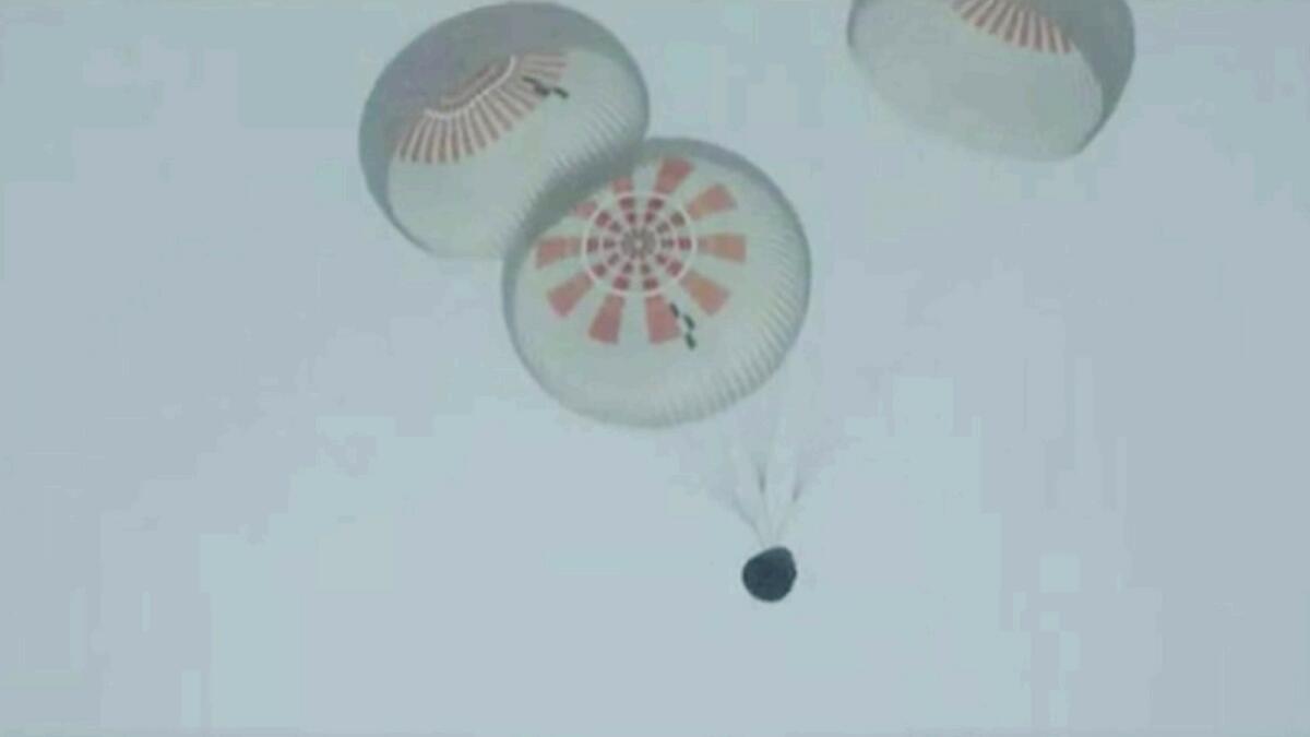 In this image taken from SpaceX video a SpaceX capsule carrying four people parachutes into the Atlantic Ocean off the Florida coast. — AP