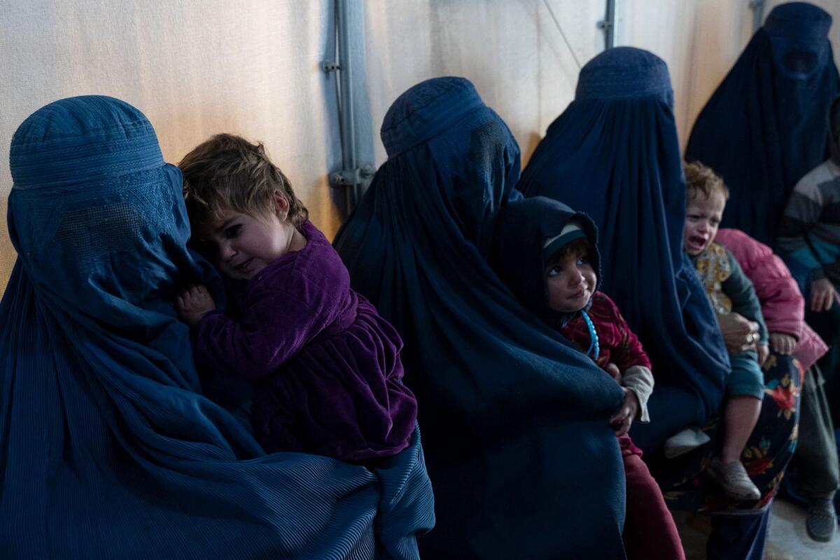 Afghan burqa-clad women and children refugees deported from Pakistan in a nutrition ward at the United Nations High Commissioner for Refugees (UNHCR) camp on the outskirts of Kabul.  — AFP