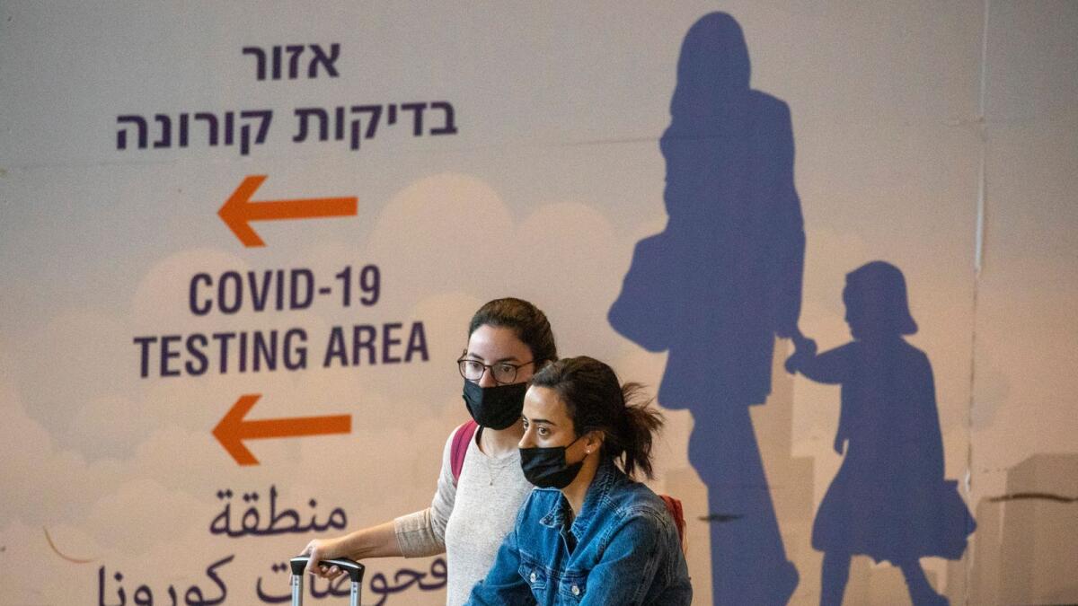 Travelers wearing protective face masks arrive at Ben Gurion Airport near Tel Aviv, Israel. – AP