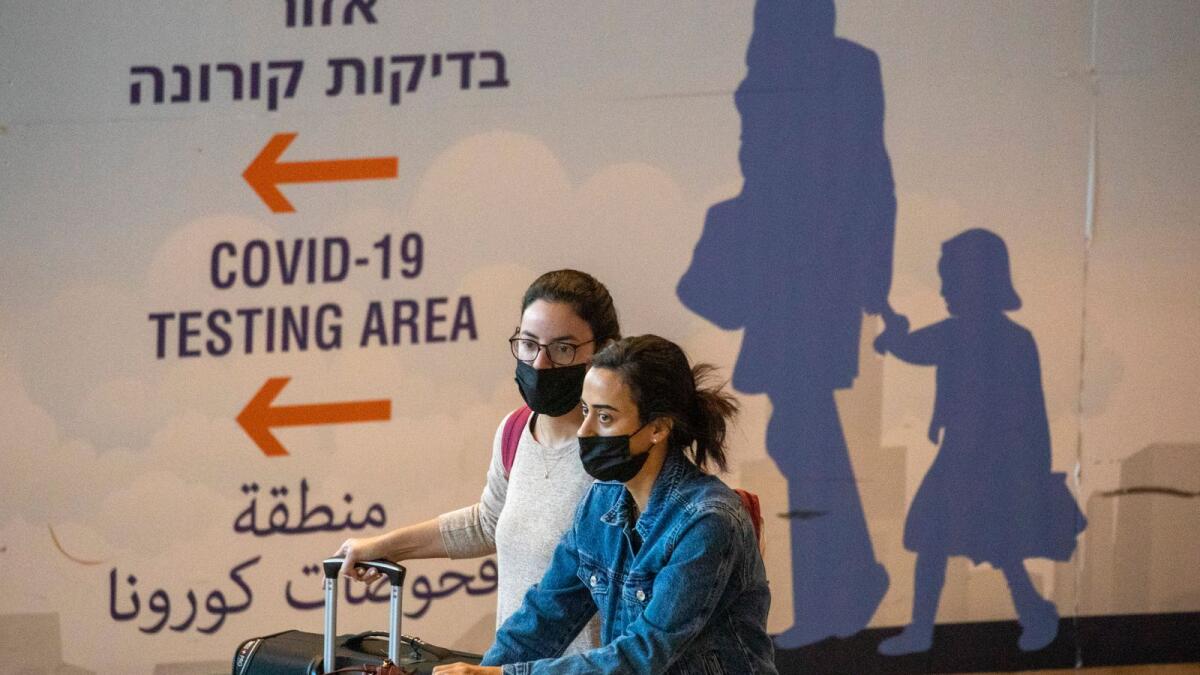 Travelers wearing protective face masks arrive at Ben Gurion Airport near Tel Aviv, Israel. – AP