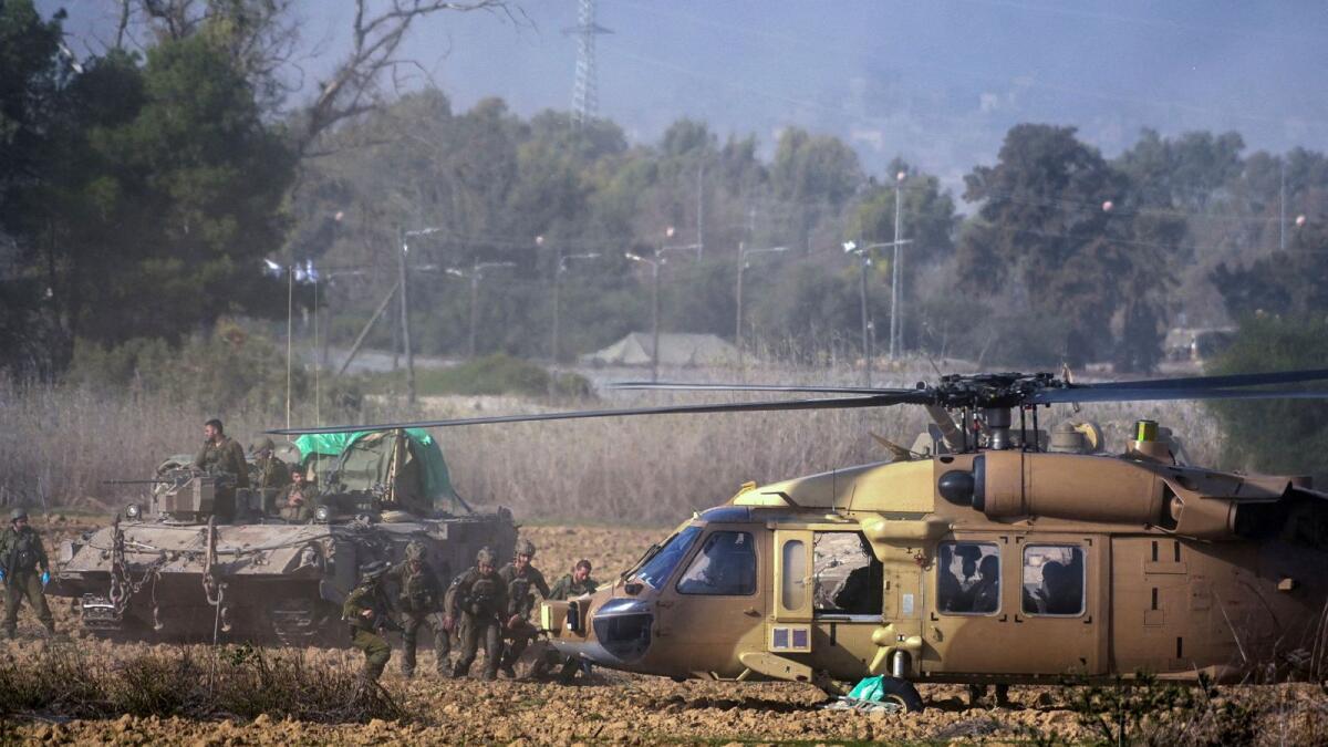 Israeli soldiers evacuate a wounded man to a military helicopter near the Gaza border on Tuesday. — Reuters
