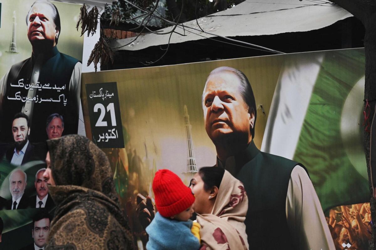 People walk past a banner of the Pakistan Muslim League Nawaz (PML N) party with an image of former prime minister of Pakistan and candidate Nawaz Sharif in Lahore on January 9, 2024 ahead of Pakistan's upcoming general election. — AFP file